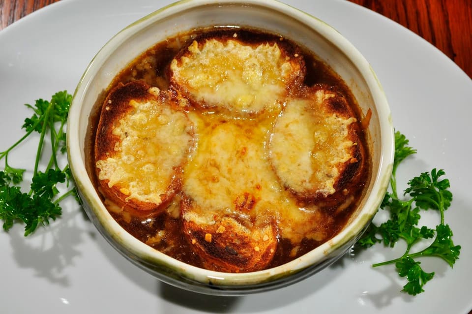 Луковый суп в керамической миске под запечённой сырной корочкой