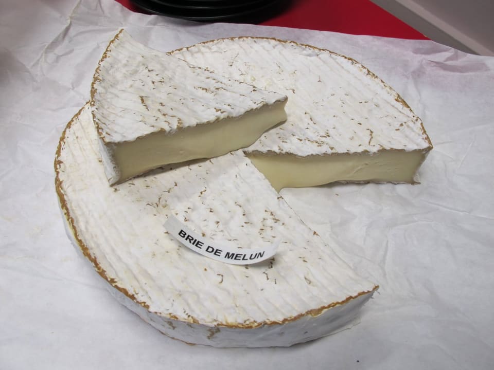 Разрезанная головка бри де Мелён с этикеткой Brie de Melun